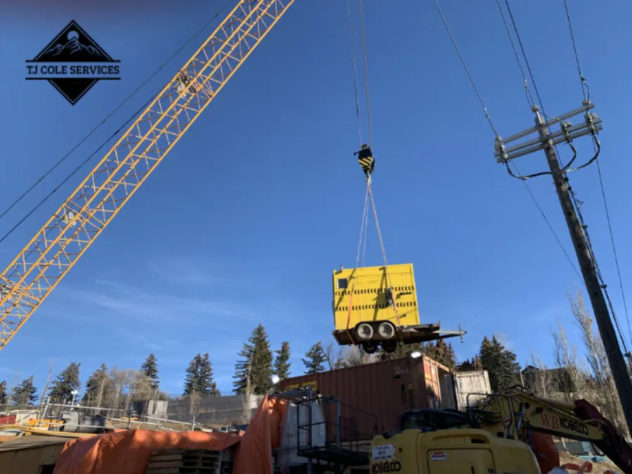 Portable emergency shower unit being placed by crane on a construction site