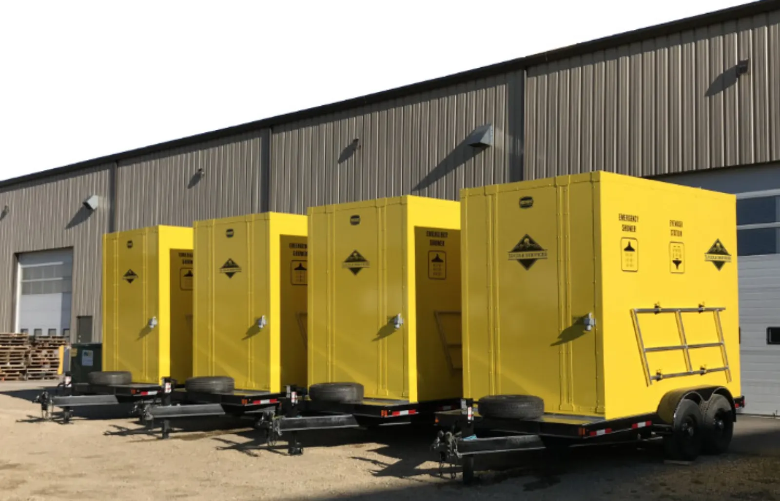 Fleet of safety-yellow emergency shower trailers staged for deployment