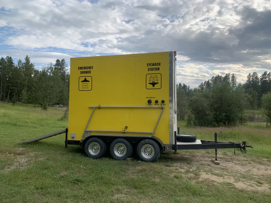 Rear of an emergency shower trailer showing tank fill, vent, and drain valves